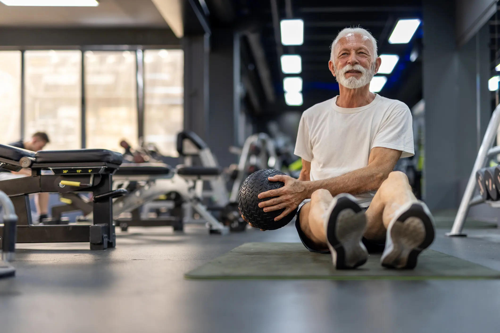 uomo terza età che si allena in palestra a corpo libero