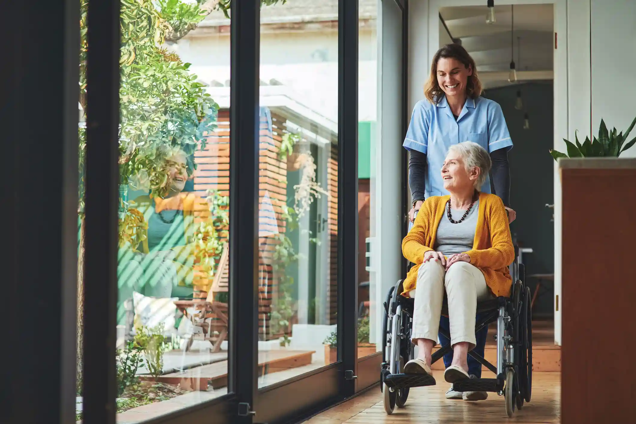 caregiver con donna anziana in carrozzina