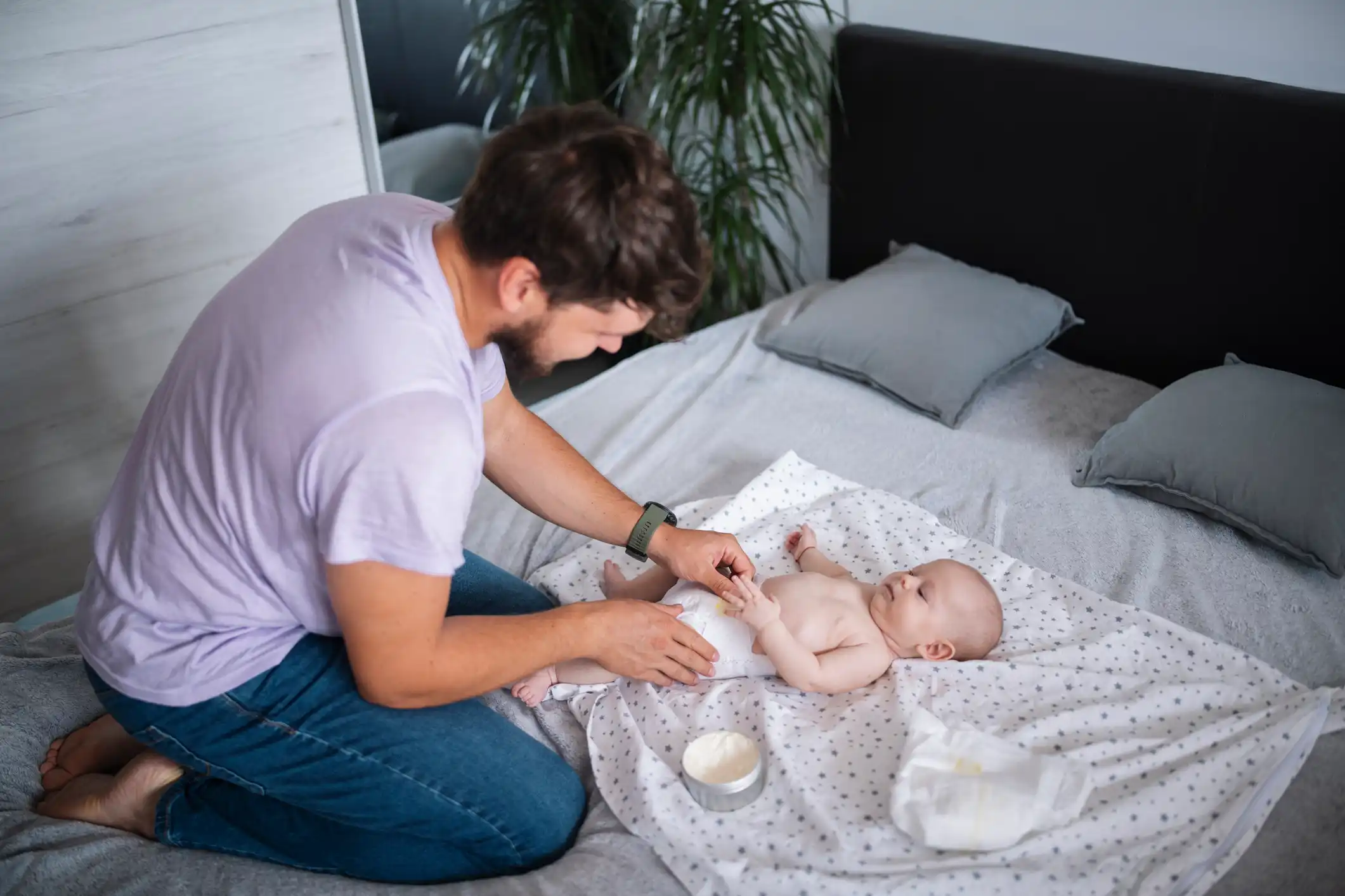 papà cambia pannolino a neonato