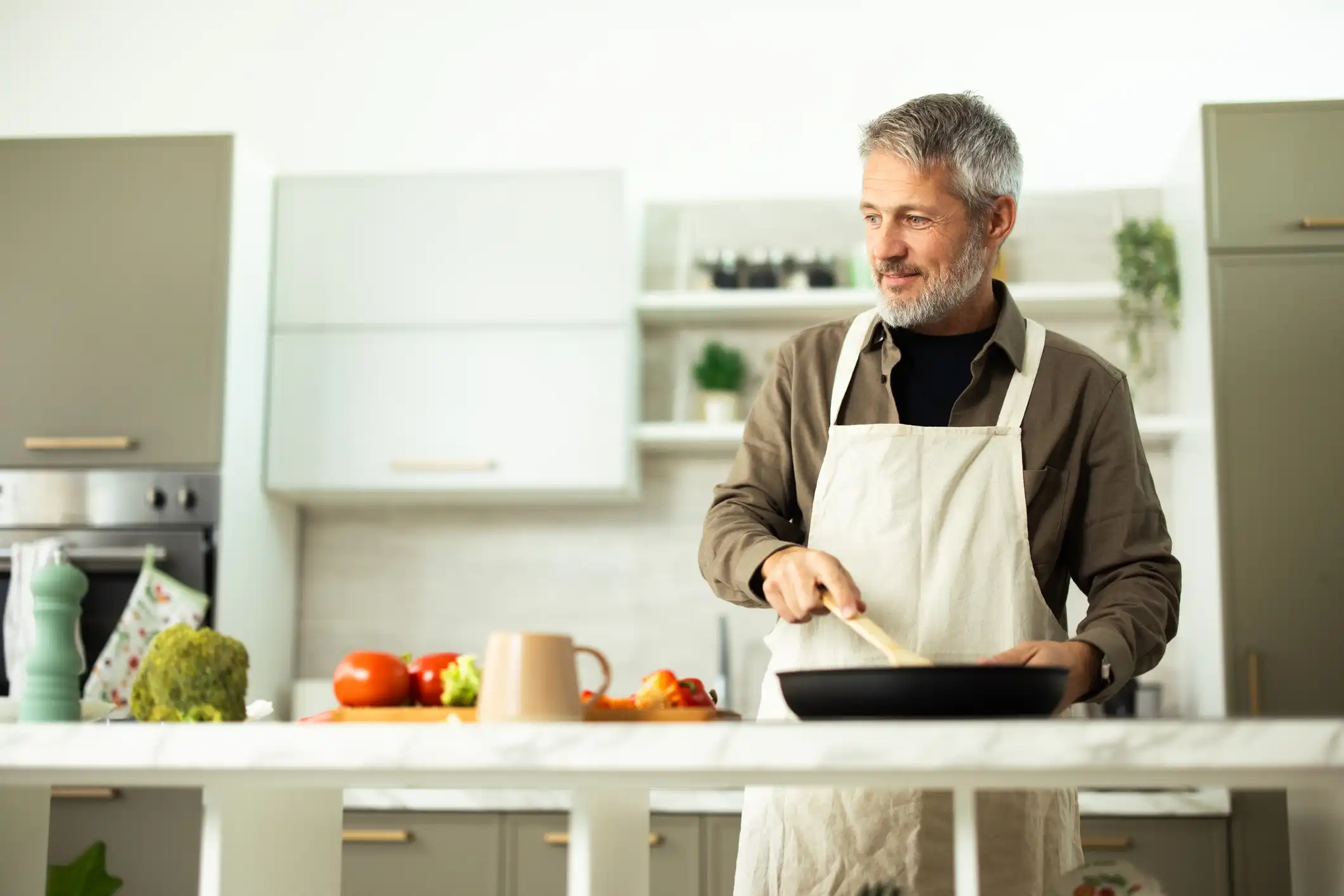 uomo cucina con padella antiaderente